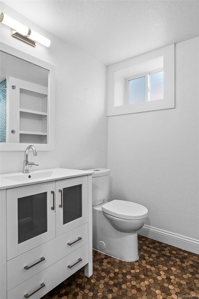 2485 S Fillmore St, Denver, CO 80210 - half bath with toilet, vanity, a textured ceiling, and tile patterned floors
