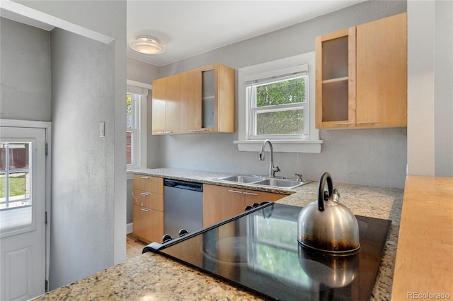 kitchen with dishwasher, light brown cabinets, light stone counters, and sink