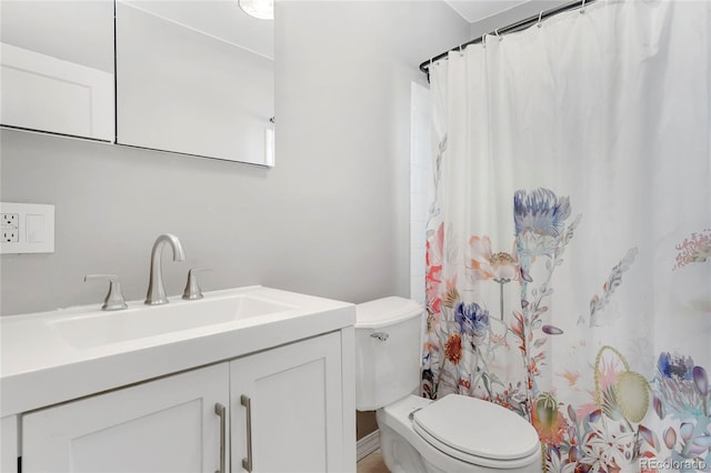 bathroom featuring vanity, curtained shower, and toilet