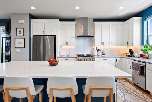 15020 Cast Pebble Cir, Parker, CO 80134 - kitchen featuring wall chimney range hood, stainless steel appliances, plenty of natural light, tasteful backsplash, and recessed lighting