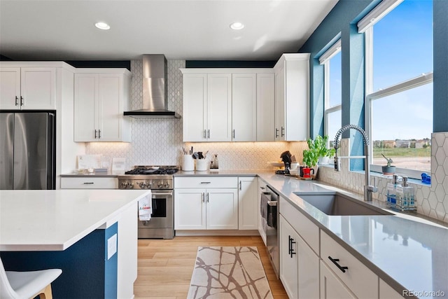 15020 Cast Pebble Cir, Parker, CO 80134 - kitchen with wall chimney range hood, appliances with stainless steel finishes, a sink, backsplash, and recessed lighting