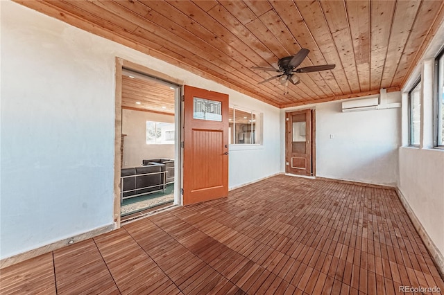 spare room featuring wood ceiling, a wall unit AC, plenty of natural light, and ceiling fan