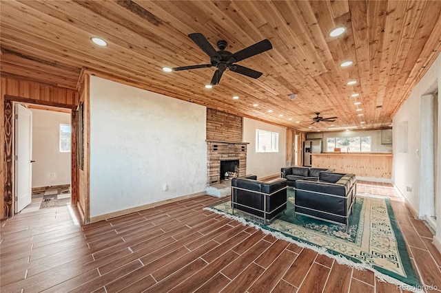 7727 County Road 521, Walsenburg, CO 81089 - living room with wood tiled floor, a stone fireplace, recessed lighting, wooden ceiling, and a ceiling fan