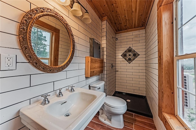 bathroom featuring wooden ceiling, toilet, sink, and tiled shower