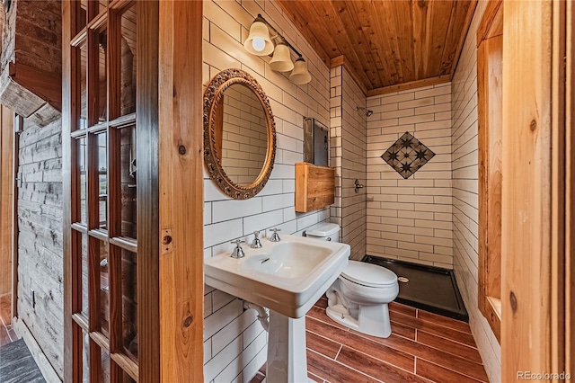 7727 County Road 521, Walsenburg, CO 81089 - bathroom featuring wooden walls, a shower stall, wood finish floors, toilet, and wood ceiling