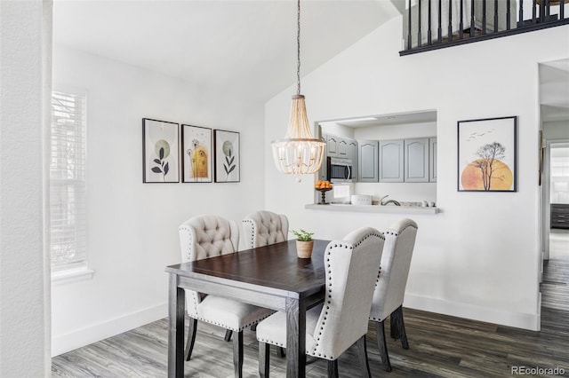 dining room with dark wood-type flooring, high vaulted ceiling, and an inviting chandelier