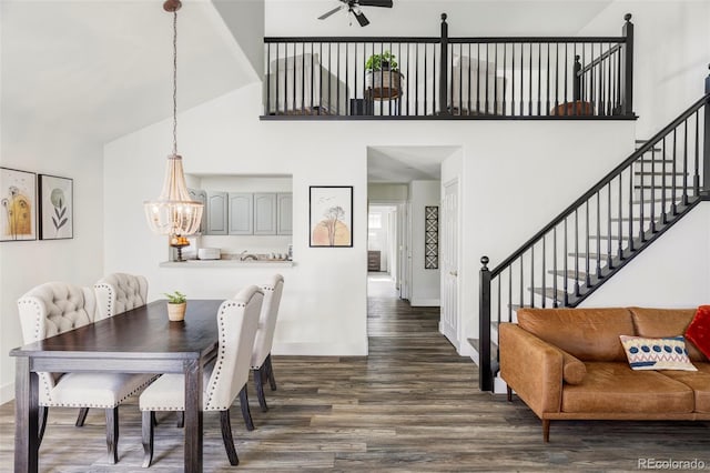 dining space with a high ceiling, stairway, and dark wood-type flooring