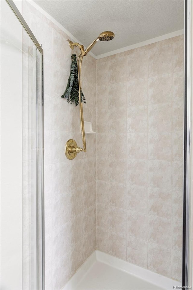 full bath with a shower stall and a textured ceiling