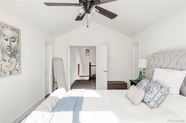 bedroom featuring lofted ceiling, wood finished floors, a ceiling fan, and baseboards