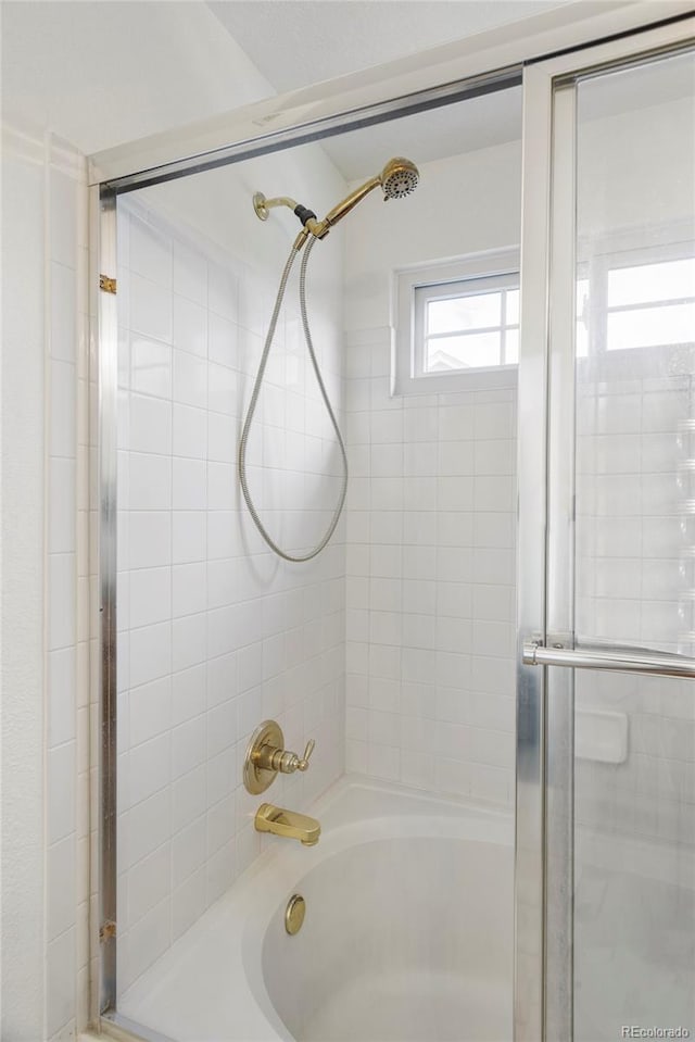 full bath featuring bath / shower combo with glass door