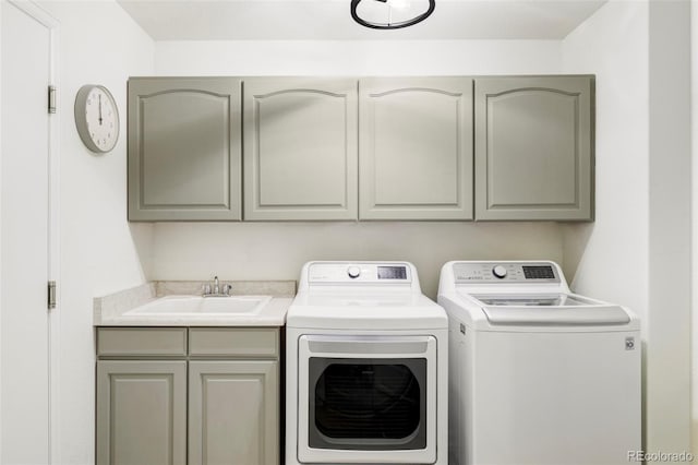 clothes washing area with independent washer and dryer, a sink, and cabinet space