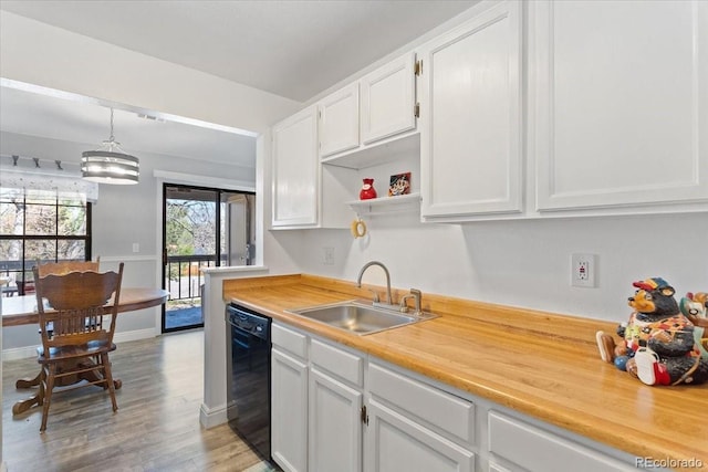kitchen featuring dishwasher, a sink, light wood-style flooring, white cabinetry, and light countertops