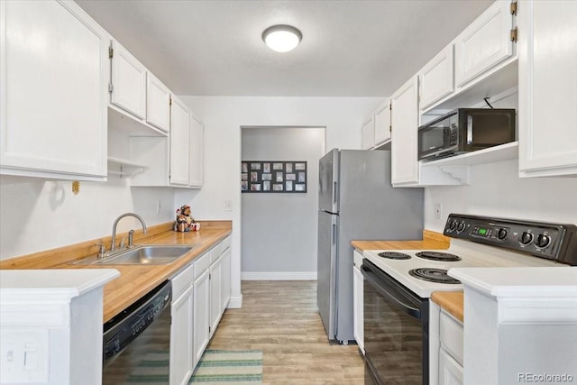 kitchen featuring black appliances, a sink, light countertops, and light wood-style flooring