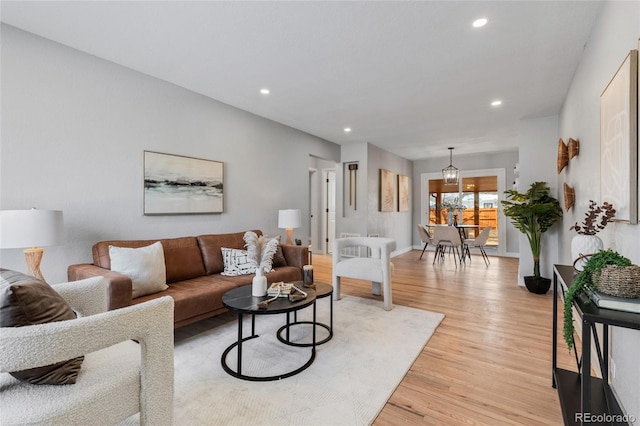 living room featuring light wood-type flooring and a chandelier