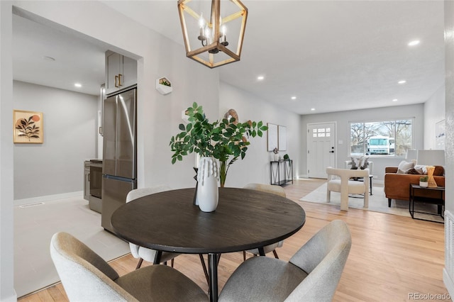 dining room featuring light hardwood / wood-style floors and a notable chandelier