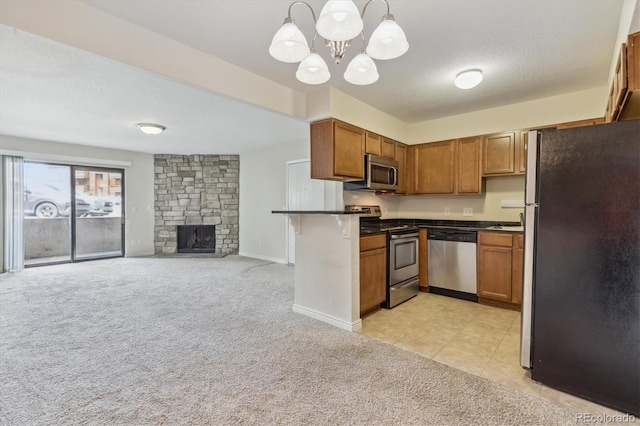 kitchen with appliances with stainless steel finishes, a chandelier, light colored carpet, dark countertops, and open floor plan