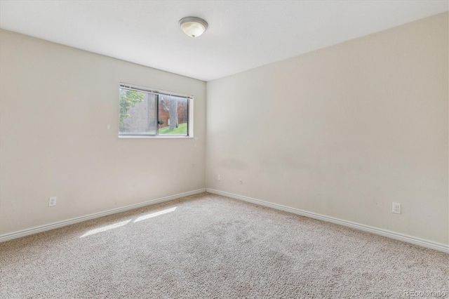 carpeted empty room with baseboards