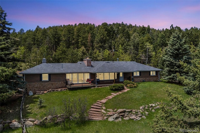 27436 Kennedy Gulch Rd, Conifer, CO 80433 - rear view of property featuring a wooded view, stone siding, a lawn, and a chimney