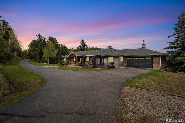 27436 Kennedy Gulch Rd, Conifer, CO 80433 - single story home featuring an attached garage, driveway, a front lawn, a chimney, and a porch