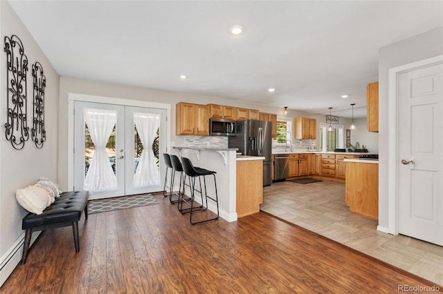 27436 Kennedy Gulch Rd, Conifer, CO 80433 - kitchen featuring appliances with stainless steel finishes, a peninsula, a kitchen bar, light countertops, and french doors