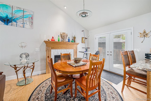 401 N Columbine St, Golden, CO 80403 - dining room featuring french doors, vaulted ceiling, light wood-type flooring, a premium fireplace, and baseboards