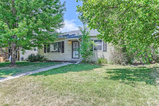 view of property hidden behind natural elements featuring a front yard