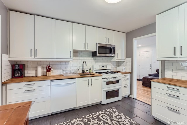 kitchen featuring wood counters, white appliances, and white cabinetry