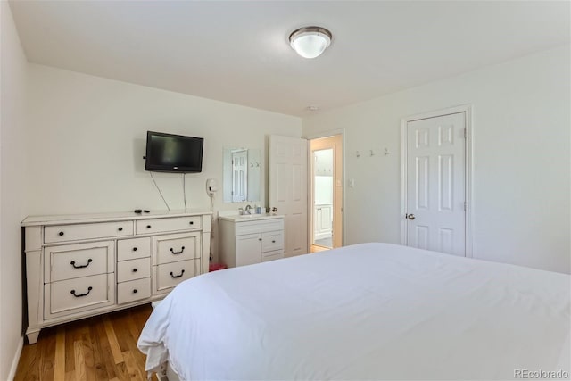 bedroom featuring ensuite bath and light hardwood / wood-style floors