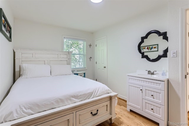 bedroom with sink and light hardwood / wood-style flooring