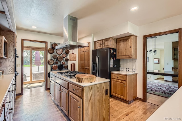 6663 S Prescott Way, Littleton, CO 80120 - kitchen featuring island exhaust hood, stainless steel gas cooktop, light wood-style flooring, light countertops, and recessed lighting