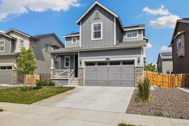 10983 Uvalda St, Commerce City, CO 80022 - view of front facade featuring board and batten siding, a porch, stone siding, solar panels, and a garage