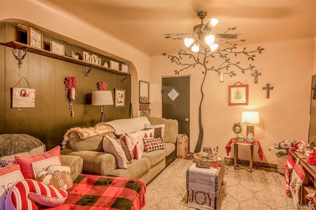 living room with light colored carpet, ceiling fan, and wood walls