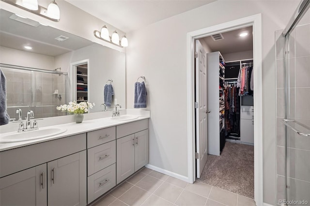 12283 W 57th Ln, Arvada, CO 80002 - full bath with a spacious closet, double vanity, tile patterned flooring, and a stall shower