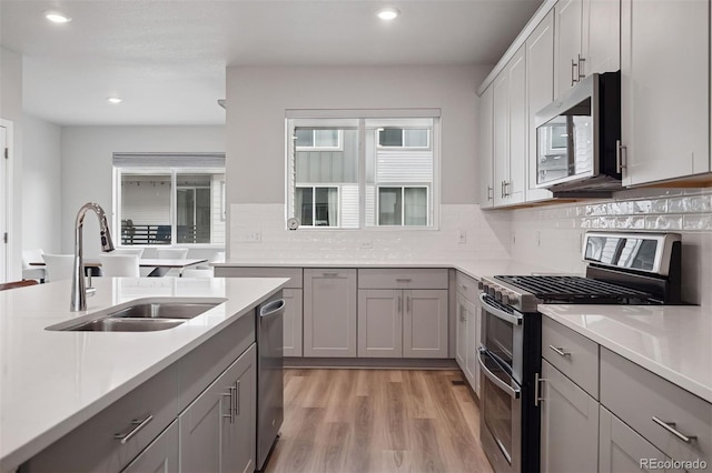 12283 W 57th Ln, Arvada, CO 80002 - kitchen featuring appliances with stainless steel finishes, gray cabinetry, light wood finished floors, recessed lighting, and light countertops