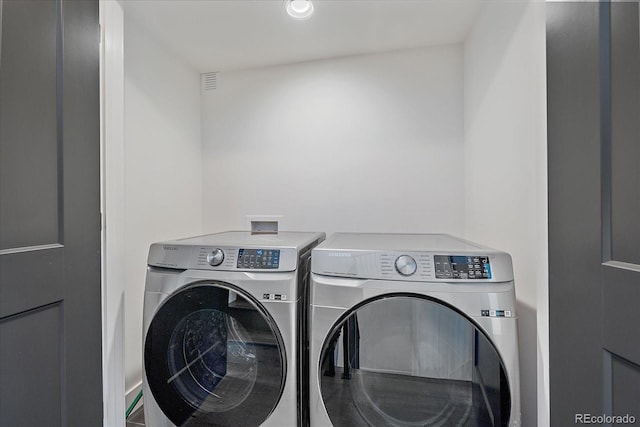 washroom featuring laundry area, visible vents, and washer and clothes dryer