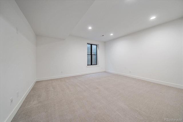 unfurnished room with light carpet, recessed lighting, and baseboards