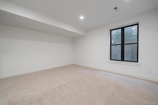 spare room with recessed lighting, visible vents, light colored carpet, and baseboards