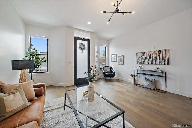 living area with a notable chandelier, baseboards, and wood finished floors