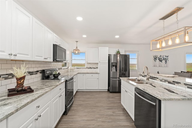 14475 Lanewood St, Brighton, CO 80603 - kitchen with appliances with stainless steel finishes, recessed lighting, decorative backsplash, white cabinets, and wood finished floors
