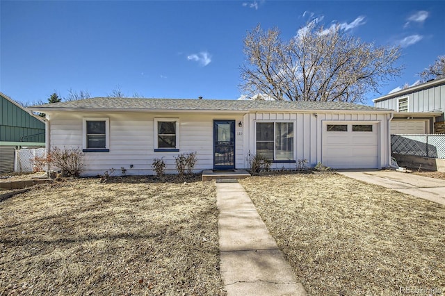 ranch-style home with driveway, board and batten siding, an attached garage, and fence