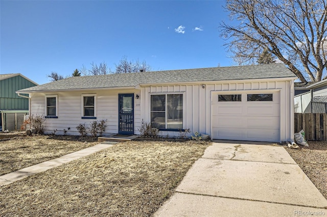 ranch-style home featuring a shingled roof, board and batten siding, fence, a garage, and driveway