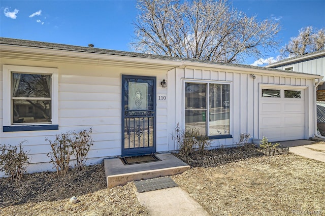 doorway to property with a garage and board and batten siding