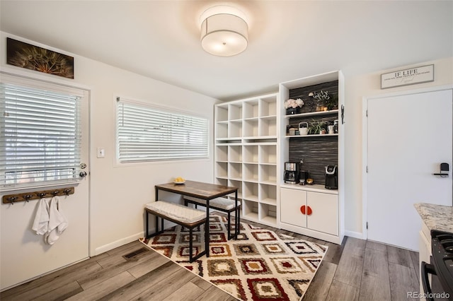 dining area featuring a wealth of natural light, baseboards, and wood finished floors