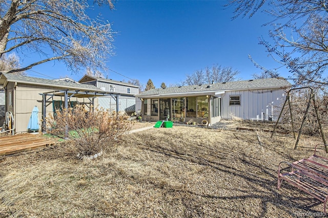 rear view of property with a wooden deck, a sunroom, and a pergola