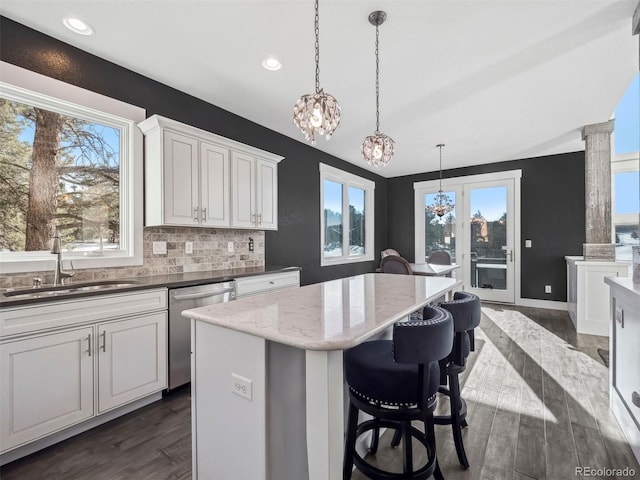 kitchen featuring pendant lighting, sink, stainless steel dishwasher, and dark hardwood / wood-style floors