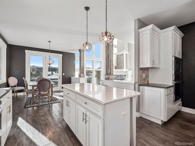 kitchen with pendant lighting, an inviting chandelier, white cabinets, oven, and dark hardwood / wood-style floors