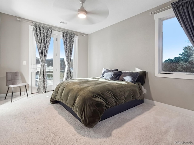 carpeted bedroom featuring multiple windows, ceiling fan, and access to exterior