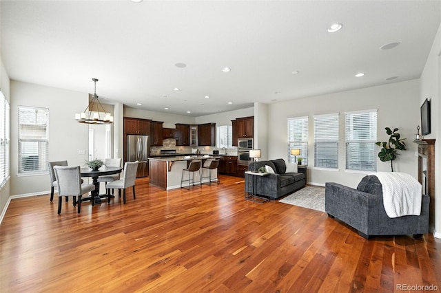10368 Bluffmont Dr, Lone Tree, CO 80124 - living room featuring wood finished floors, plenty of natural light, recessed lighting, and a chandelier