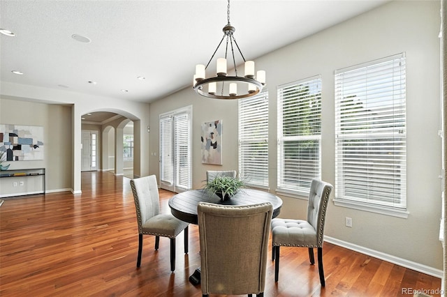 10368 Bluffmont Dr, Lone Tree, CO 80124 - dining area featuring arched walkways, a chandelier, wood finished floors, healthy amount of natural light, and recessed lighting