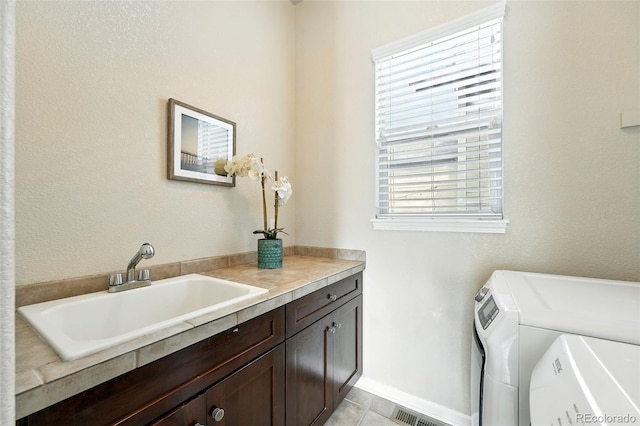 10368 Bluffmont Dr, Lone Tree, CO 80124 - laundry room featuring cabinet space, washing machine and dryer, and light tile patterned flooring